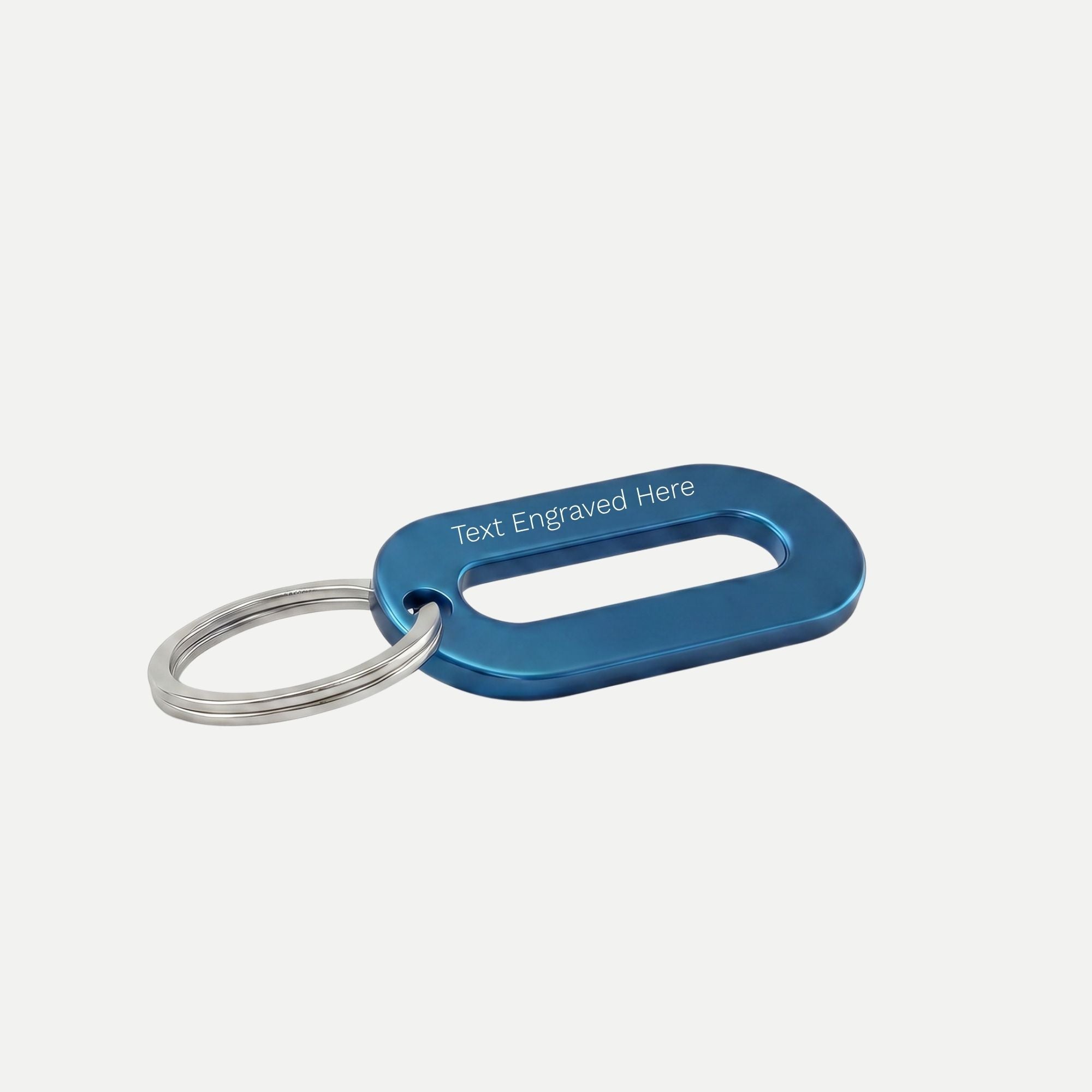 A metallic blue keyring showing text engraved here on a white background