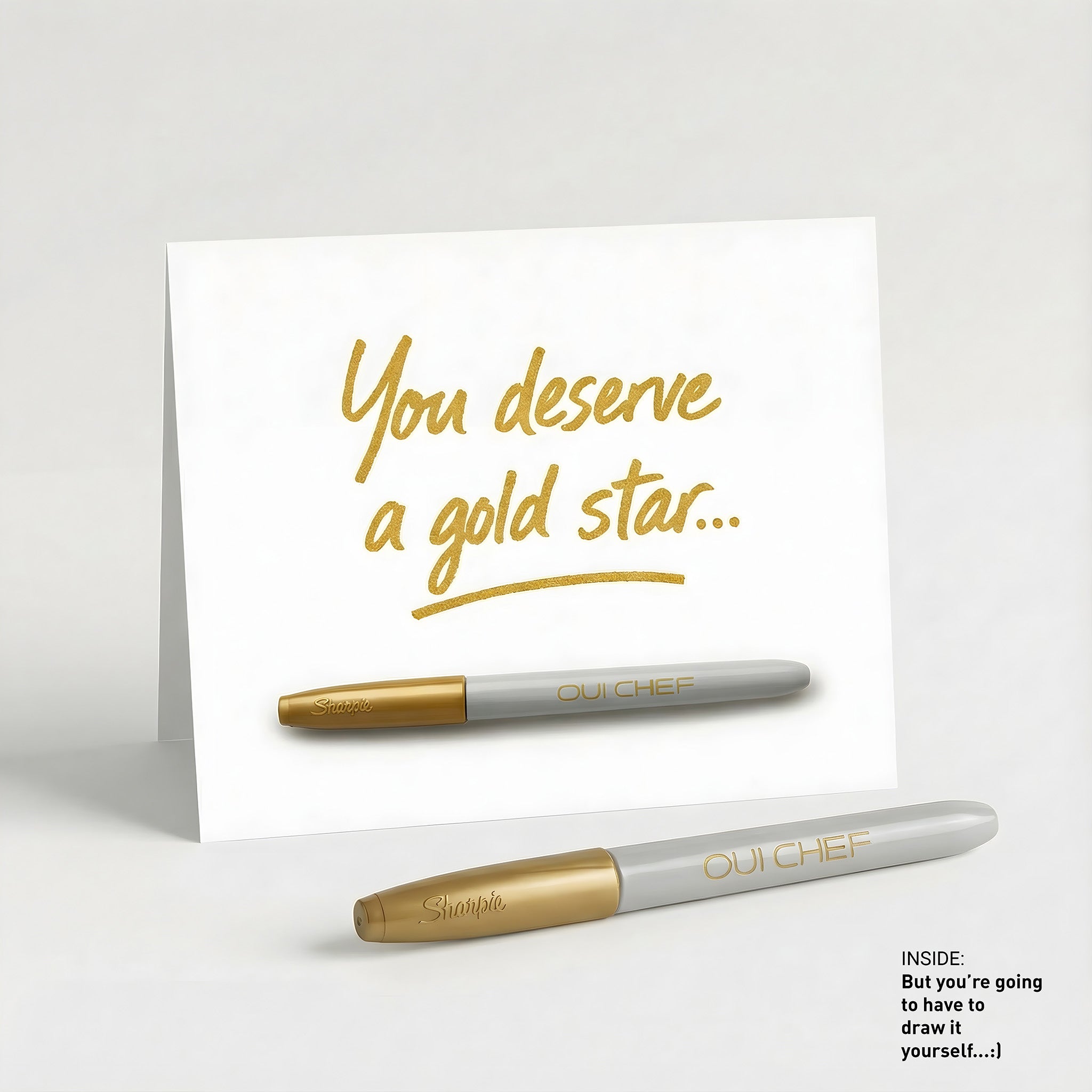 Oui Chef "Gold Star" Greeting card standing against a white background with a sharpie placed beside it.