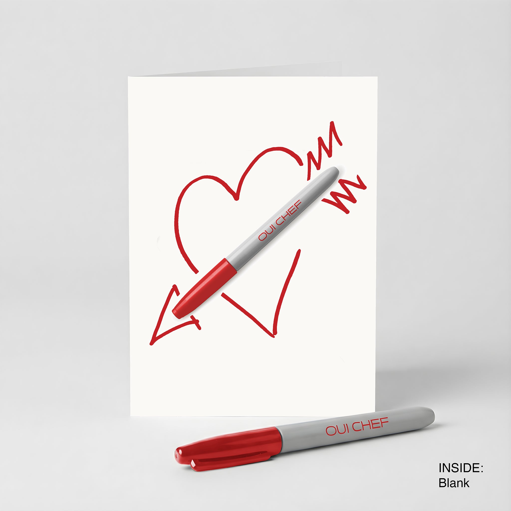 Valentines card with a Sharpie through the heart and a red Sharpie on a white background.
