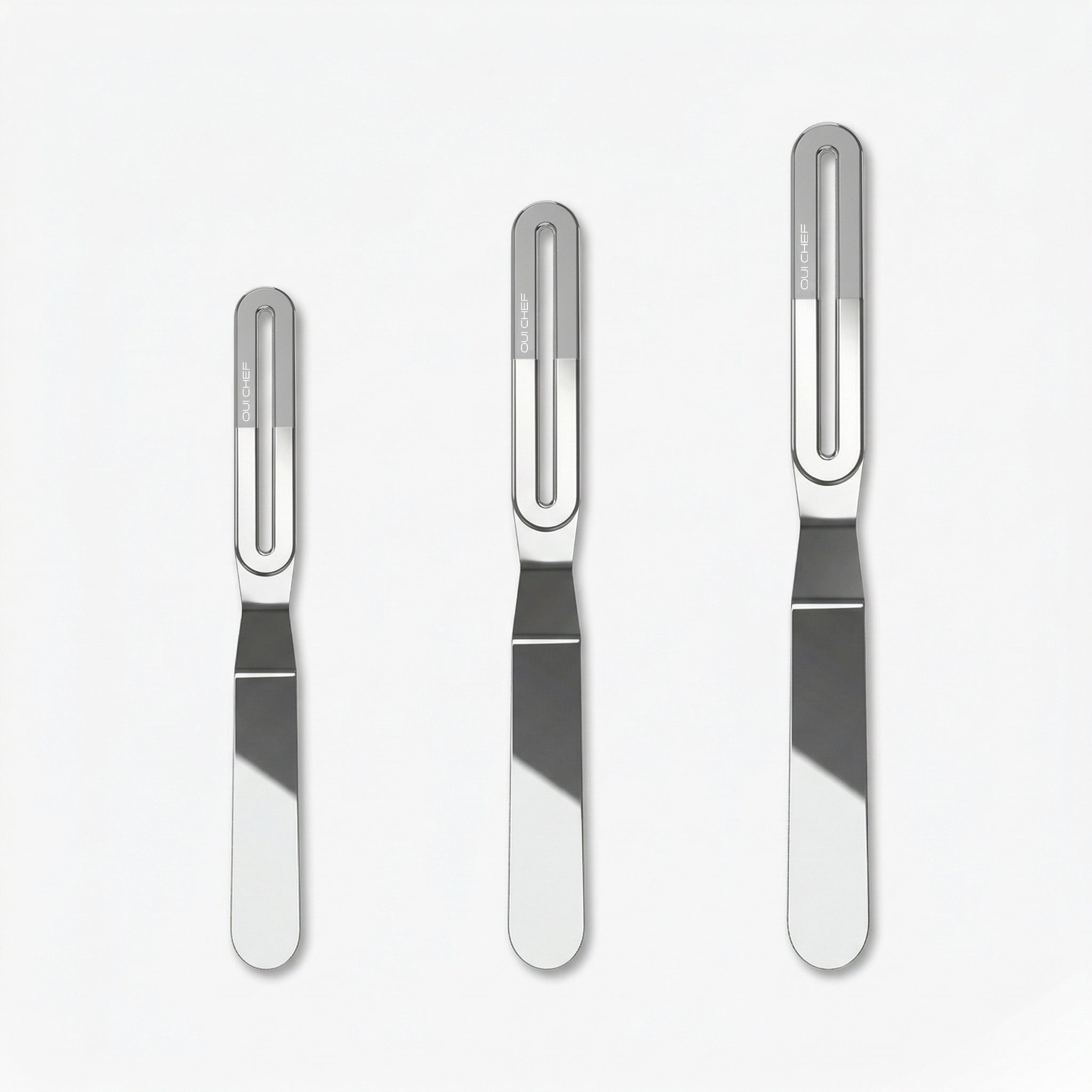 Three stainless steel offset palette knives of increasing size, each with a sleek metal blade and a chrome ergonomic handle labeled “OUICHEF,” arranged side by side on a light background.