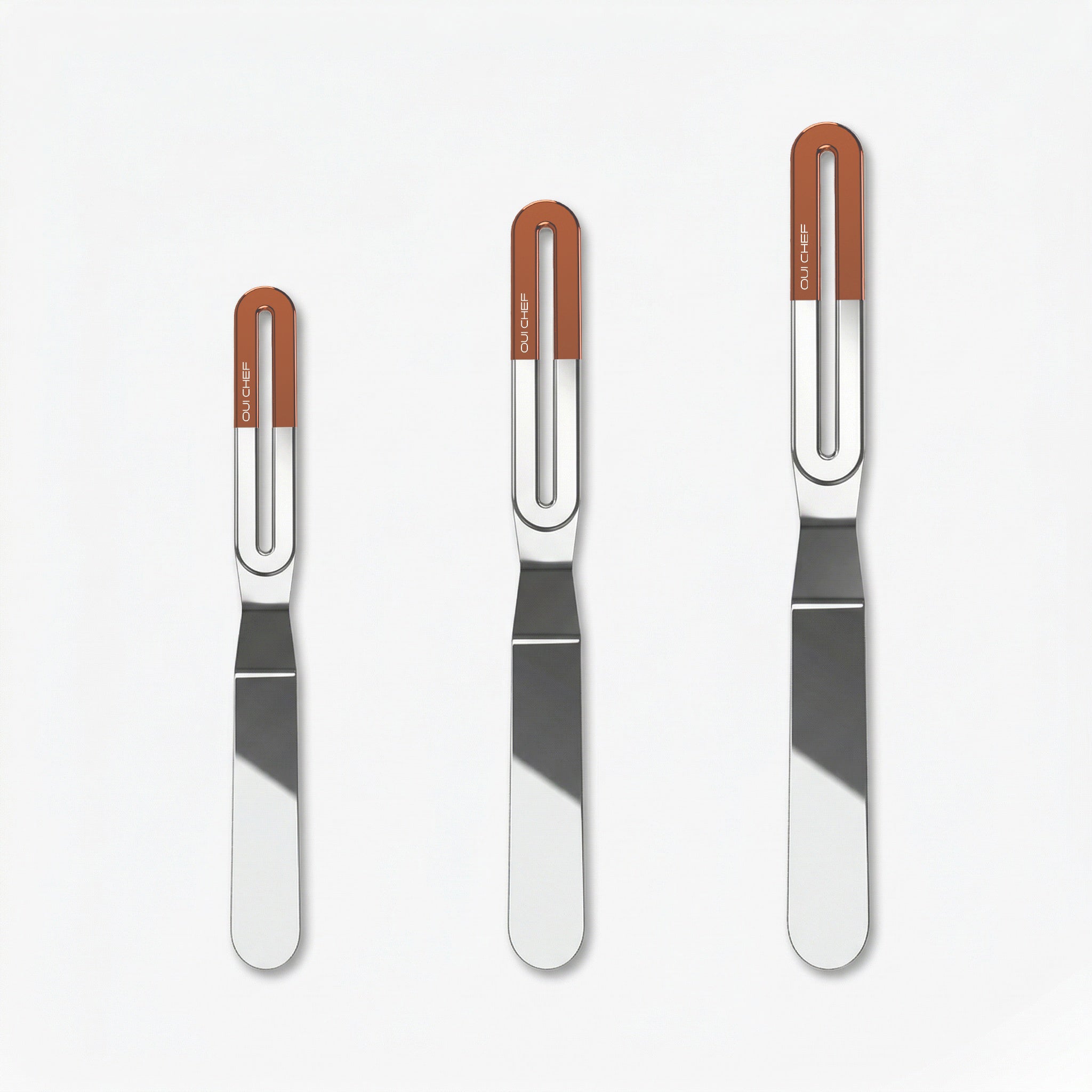 Three stainless steel offset palette knives of increasing size, each with a sleek metal blade and a copper top ergonomic handle labeled “OUICHEF,” arranged side by side on a light background.