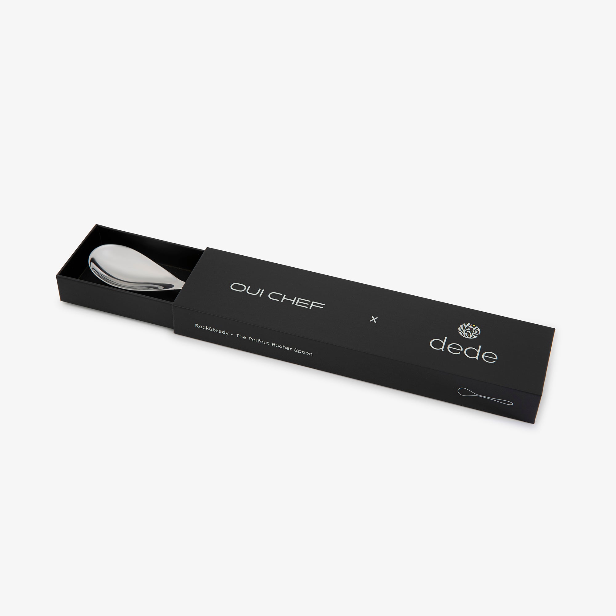Black packaging box with a stainless steel rocher spoon inside, featuring 'Oui Chef' and 'dede' branding against a white background.