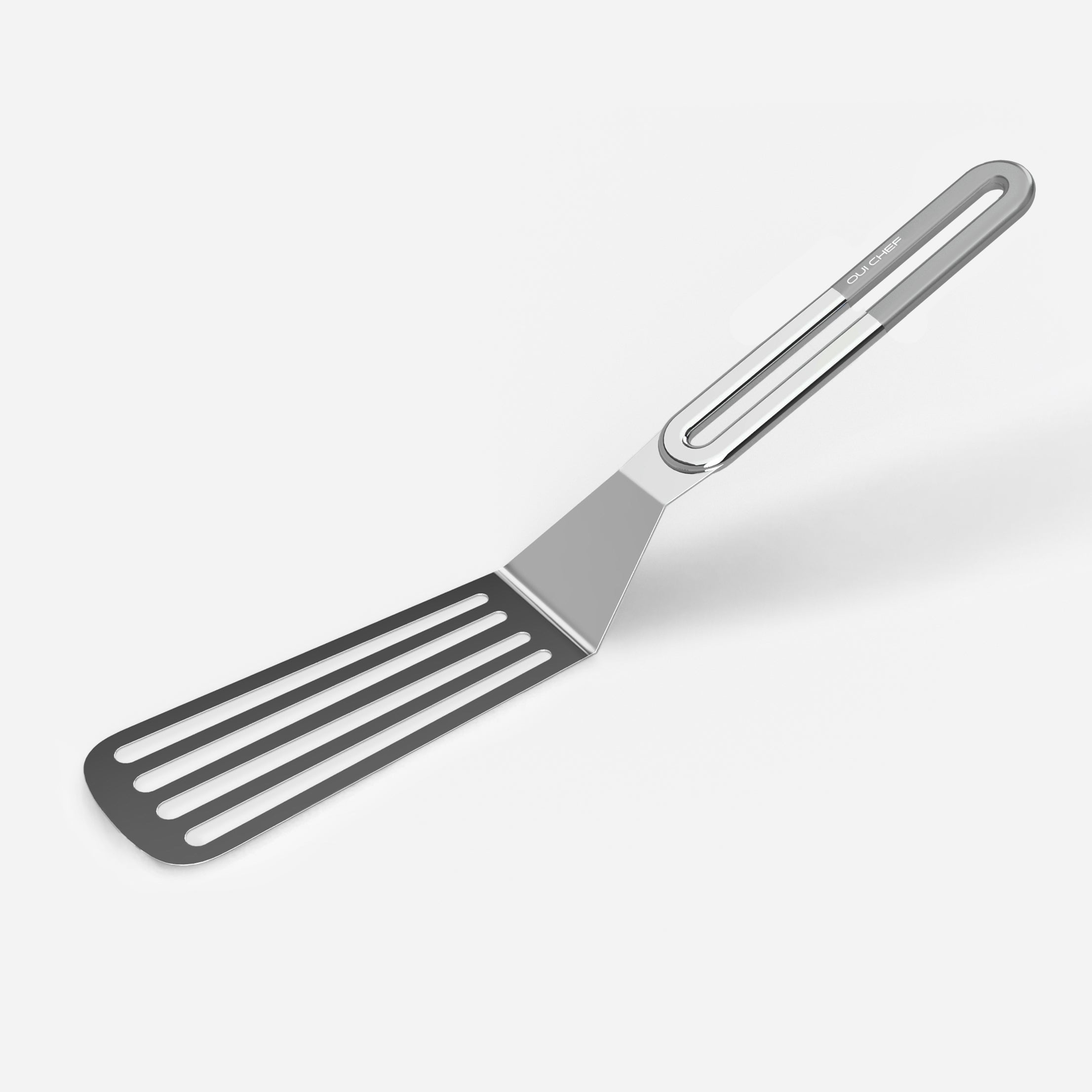 A stainless steel slotted spatula with a chrome coloured handle against a white background.